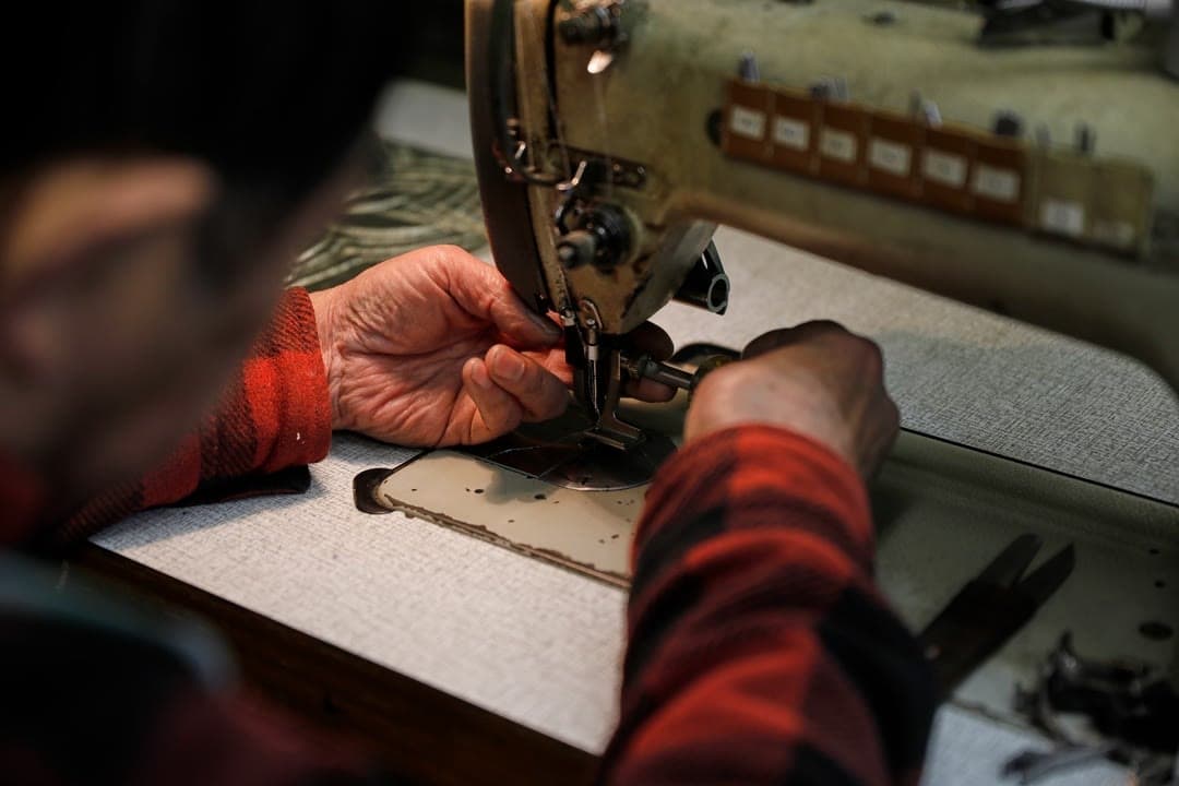 An artisan sewing at the machine